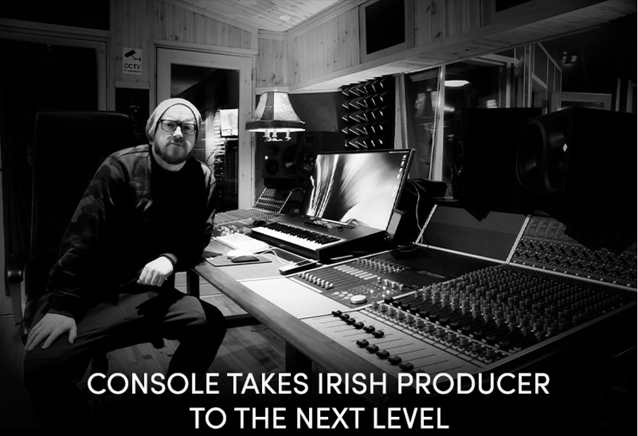 Stuart Gray sitting next to Audient APS8024-HE mixing console in studio