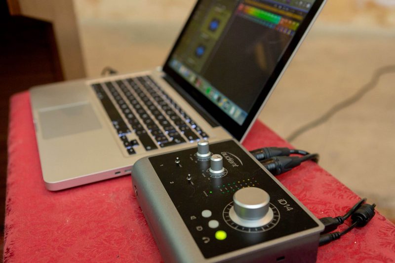 Interfaz de audio Audient iD14 emparejada con el MacBook de George para grabación móvil